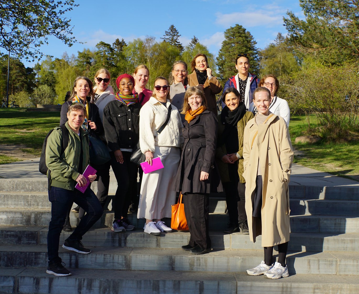 A group of 13 persons outside in a sculpture park