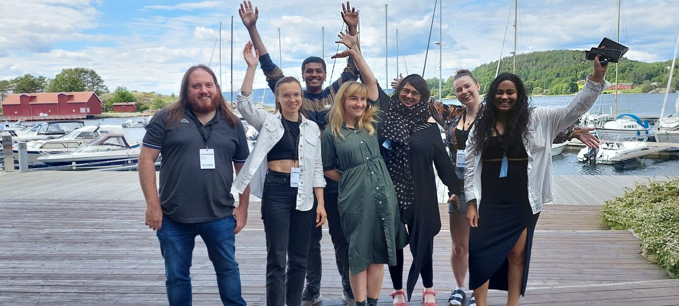 6 people standing outside at a harbor