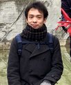 Taro Kitazawa in a dark jacket and scarf with an outdoor background