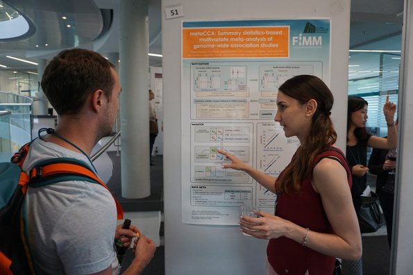 A man and a woman looking at a poster of scientific data