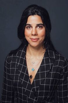 Dr. Irep Gözen in a black and white checkered top in a dark background