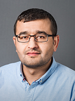 Aziz Khan in a light blue shirt on a gray background